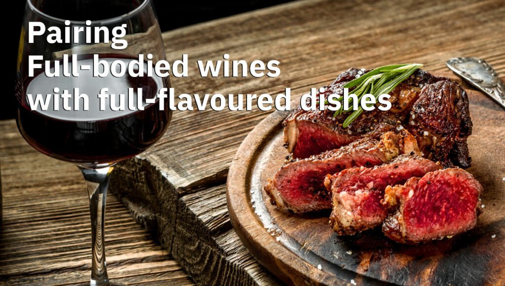 Red wine glass with a plate of steak on a table